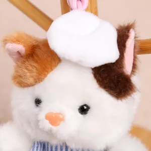 Joli pendentif chat en peluche avec toque de chef et bavoir rayé, parfait accessoire de sac.
