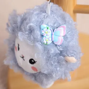 Close-up of the cute blue curly sheep plush pendant with a sweet butterfly and flower detail.