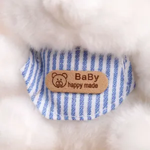 Gros plan sur les détails d'une peluche, tissu blanc doux avec bavoir rayé et étiquette.
