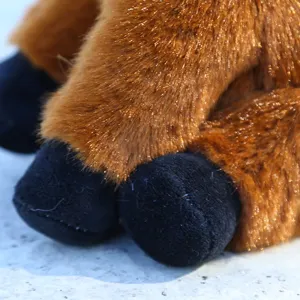 Detalle de peluche de vaca de las Tierras Altas, pelo marrón suave y pezuñas negras, animal tierno