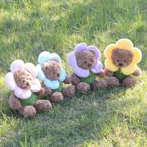 Detailansicht süßer Plüschteddybären mit bunten Blumenkragen sitzend auf grünem Gras.