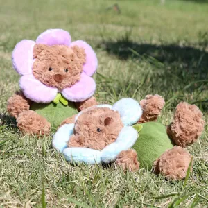 Weicher Plüsch Blumen Bär Detail, süßer brauner Teddybär mit rosa und blauen Blütenblättern.