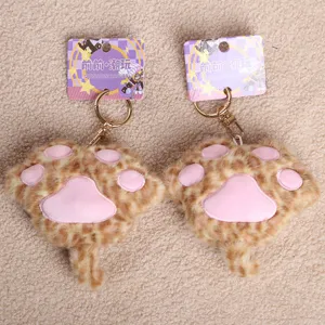 Detail view of soft cute animal cat paw plush toy keychain pendant, fluffy texture and cute design.