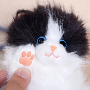 Cute fluffy longhair cat plush toy keychain detail, soft black and white fur with pink paw.