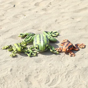 Detailed view of three flat simulation plush frog toys presented on a sandy beach background.