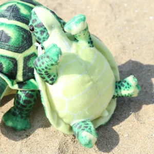 Close up detail view of cute simulation plush turtle toy with lanyard on sandy beach.