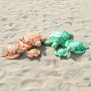 Detailed view of colorful simulation sea turtle plush toys arranged on sand, soft stuffed animal.