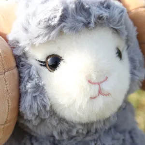 Cute big horned sheep plush toy detail close up, fluffy gray wool and soft white face.