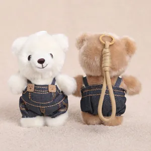 Primo piano dettagliato del simpatico portachiavi in peluche orsetto con salopette di jeans.