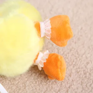Plüsch gelbe Ente Spielzeug Detail mit süßen orangen Füßen und rosa Rüschen Dekoration.