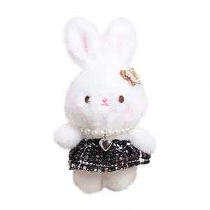 Grazioso ciondolo con coniglietto di peluche bianco con collana di perle e gonna in tweed nero.