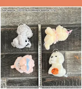 Close-up detail shot of cute plush toy dog keychains with accessories on wooden table.