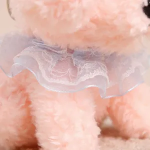 Pink plush teddy dog pendant detail showing soft fur and blue lace collar decoration.