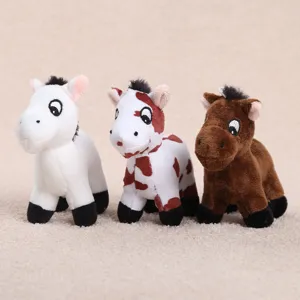 Primo piano di tre simpatici giocattoli pendenti di pony in peluche bianchi maculati e marroni.