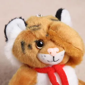 Vista di dettaglio del peluche di tigre di simulazione, morbida bambola con sciarpa rossa.
