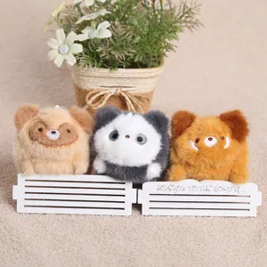 Détail de peluche montrant trois charmants pendentifs animaux de dessin animé sur clôture.