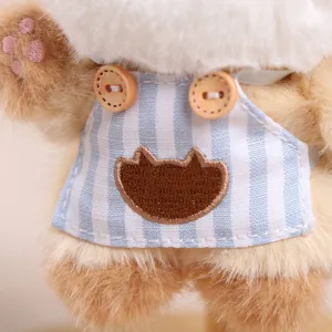 Detailed shot of cute plush cat toy with striped apron and soft brown fur texture.