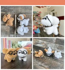 Detail van de schattige pluche puppy sleutelhanger met een bril en een klein belletje.