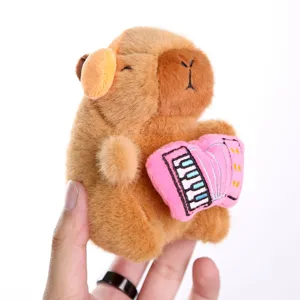 Peluche marron mignonne de capybara tenant un instrument rose pendentif vue de détail pour sacs.