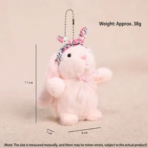 Llavero de conejo de peluche rosa con diadema floral, vista detallada del bonito colgante de muñeca.