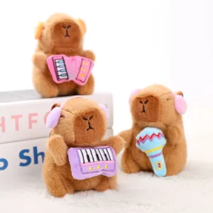 Joli porte-clés en peluche capybara avec instruments de musique et écouteurs mignons.