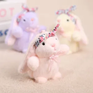 Vista detallada del tierno llavero de conito de peluche con diadema floral y lazo bonito.