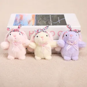 Detalle de llavero de conejo de peluche con bonita diadema floral y lazo rosa tierno.