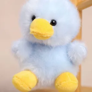 Close up detail view of cute fluffy blue duck plush toy featuring bright yellow beak.