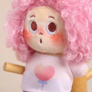 Primo piano dettagliato del ciondolo in peluche stella afro rosa soffice con viso ricamato.