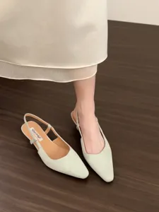 Detailed view of light green suede pointed-toe slingback low heel shoes with elegant design.