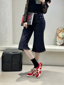 Detailed view of red casual flat sneakers with white side stripes and lace-up design.