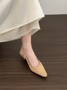 Close-up detail of women's suede slingback low heel pointed toe shoes in elegant beige style.
