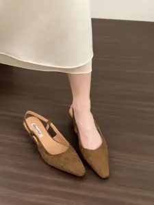 Detailed view of women's brown suede pointed toe low heel slingback sandals, elegant texture.