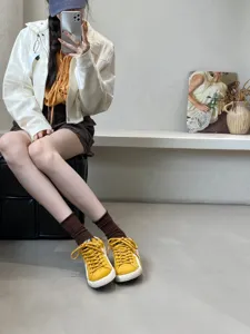 Detailed view of women casual trainer shoes in yellow leather with iconic star design and flat sole.