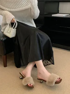 Primer plano de las elegantes zapatillas peludas con punta cuadrada abierta y diseño cómodo.