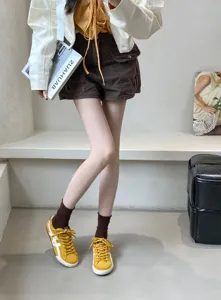 Detailed view of women's retro yellow casual sneakers, trendy low-top flat shoes for daily wear.