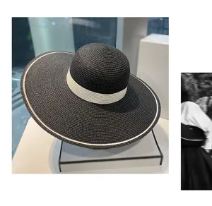 Vista dettagliata del cappello di paglia nero a tesa larga con bordo bianco estivo