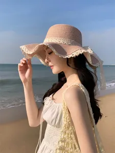 Vue detaillee du chapeau de paille d'ete avec dentelle delicate et bord ondule pour femmes.