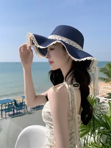 Vue latérale détaillée d'un chapeau de paille bleu marine avec bord en dentelle blanche pour femmes.