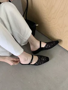 Close-up detail of stylish black hollow square-toe flats featuring delicate strap design.