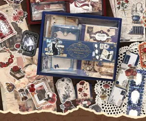 Vintage scrapbooking gift set with journaling supplies, stickers, and decorative paper for crafts.