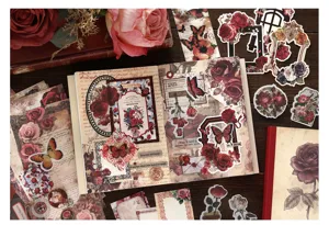 Vintage scrapbooking journal material kit with aesthetic floral stickers and paper pages.