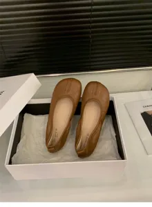 Vista dettagliata di ballerine marroni con punta divisa, scarpe basse comode da donna.