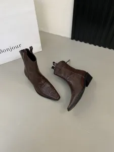 Brown pointed toe western cowboy boots with chunky block heels, retro style detail shot.