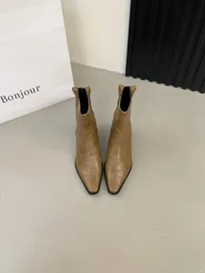 Close-up detail of vintage brown block heel western boots showcasing textured leather finish.