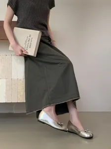 Primo piano di ballerine tabi metallizzate con suola morbida e dettaglio di fiocco delicato.