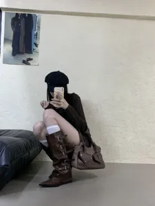 Detailed shot of French retro dark brown pointed-toe knee-high boots with multiple straps.