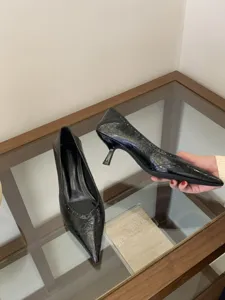 Detailed view of women's black pointed-toe kitten heel shoes, elegant office wear style.
