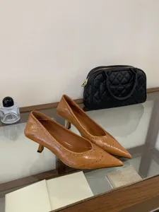 Detail view of brown patent leather pointed kitten heels, elegant commuter style footwear.