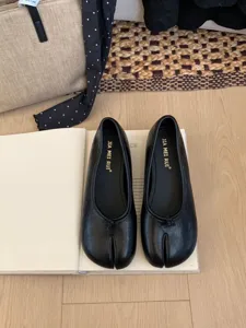 Primer plano de zapatos planos Mary Jane negros con punta dividida, estilo retro francés.